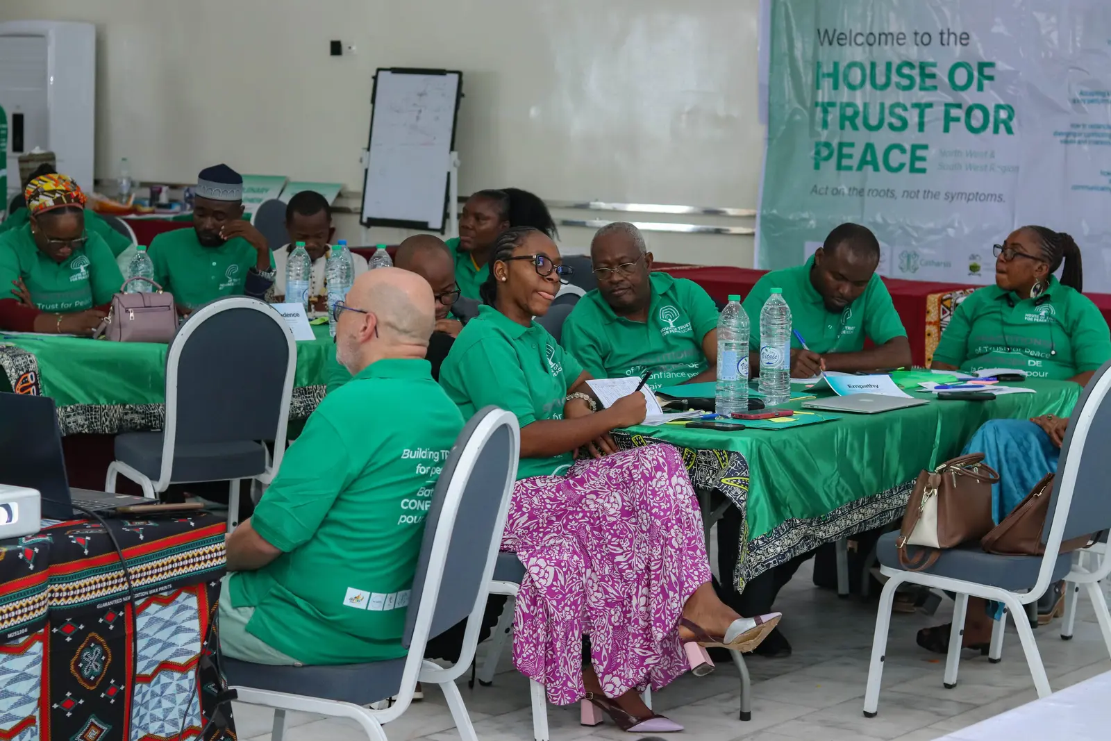 Participants engaged in table discussion at the House of Trust for Peace workshop in Buea